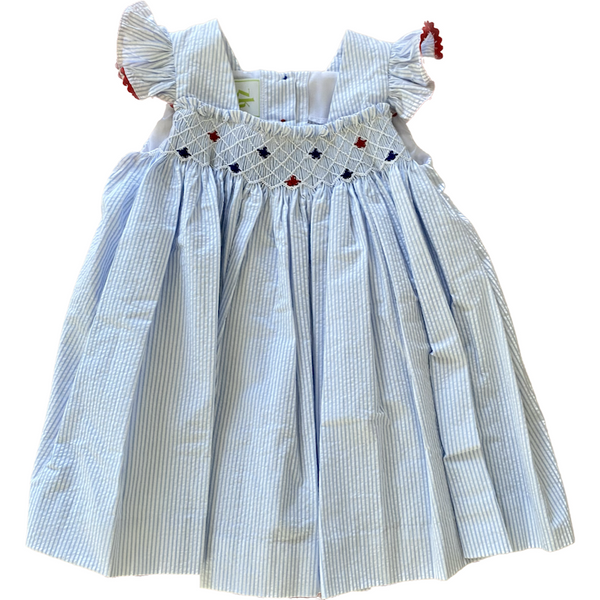 LIght blue and white seersucker dress with star smocking on the chest and coordinating red trim on ruffle sleeves.