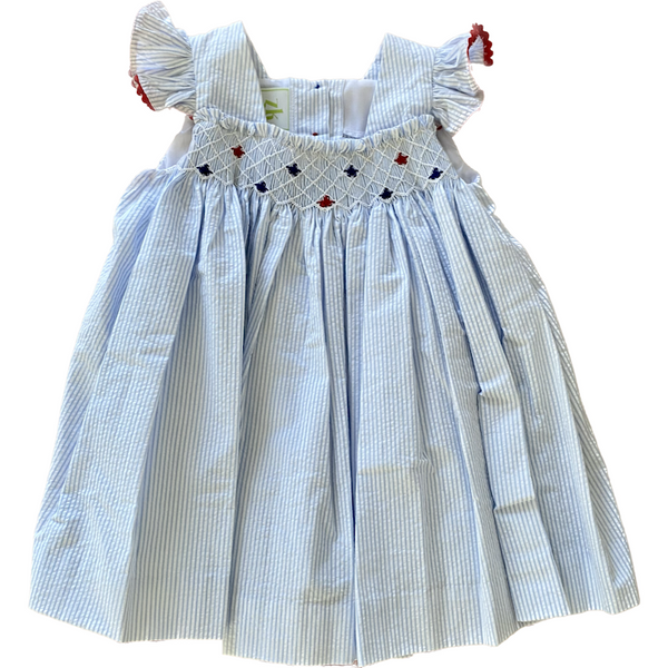 LIght blue and white seersucker dress with star smocking on the chest and coordinating red trim on ruffle sleeves. 