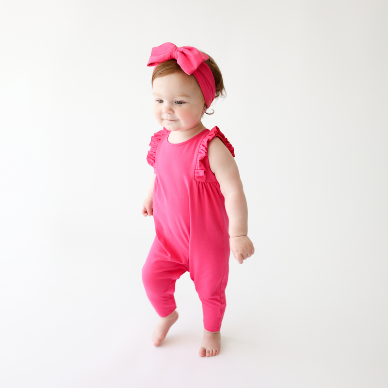 Girl's hot pink romper with long pants and sleeveless top. Features ruffles at the shoulders, soft & stretchy material, and snaps for easy diaper changes. A great outfit for transitioning to spring! 