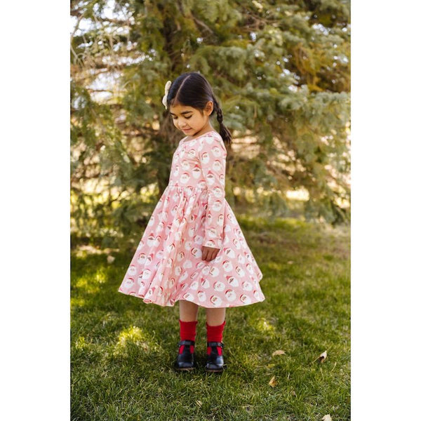 Soft, twirly pink dress with festive Santa print. This adorable long sleeve Santa Christmas dress is perfect to dress up or dress down for all your holiday occasions. 