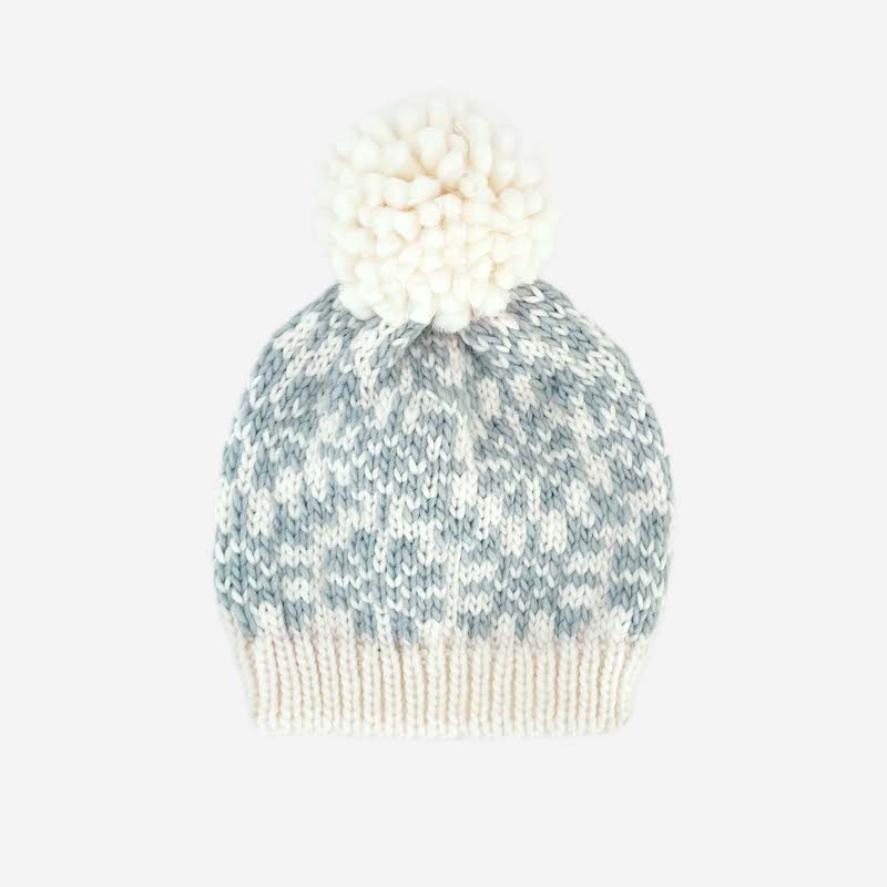 Cream knit hat with pom pom and blue grey snowflake detail. 